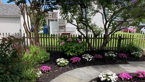 A landscaped garden with a curved pathway, various flowering plants, and a wooden fence. - One Short Block to Beach - Spacious Victorian - 1st Floor Bed and Bath (Cape May)