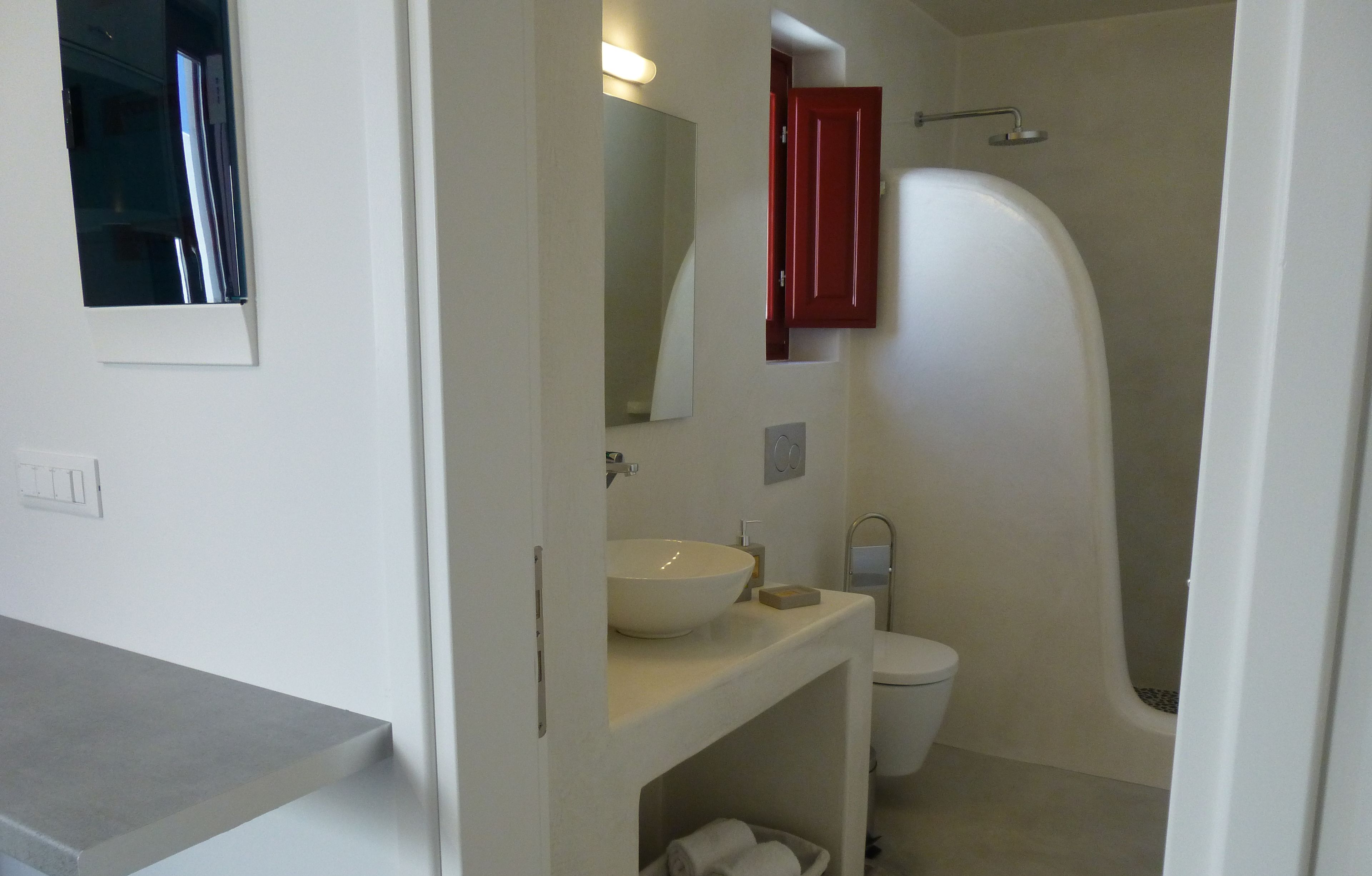 A bathroom with a white sink, a toilet, and a shower.