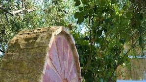 Un pozo de piedra con un caño y una cuenca de piedra.