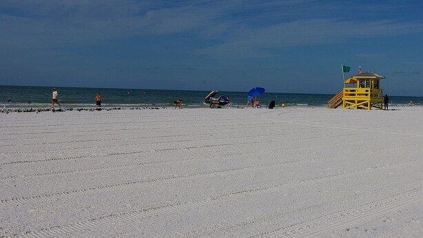 A beach with a lifeguard tower, clear skies, and a few people. - 5 minutes drive to nr Siesta Key 1/1 Large condo. The pool heated (Sarasota)