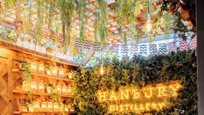 Een gezellig restaurantinterieur met een houten tafel, stoelen en een neonbord met de tekst 