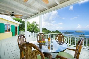 A covered outdoor dining area with a table, chairs, and a view of the ocean. - Book Your summer dates Now no passport required!! (St Thomas U.S.V.I)