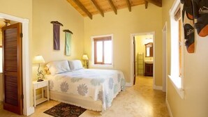 Quarto com uma cama, mesa de cabeceira, janela e porta.