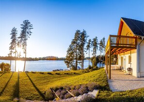 A lakeside property with a wooden deck, a covered patio, and a view of the lake. - Lakeside Village Větrník (Frymburk)