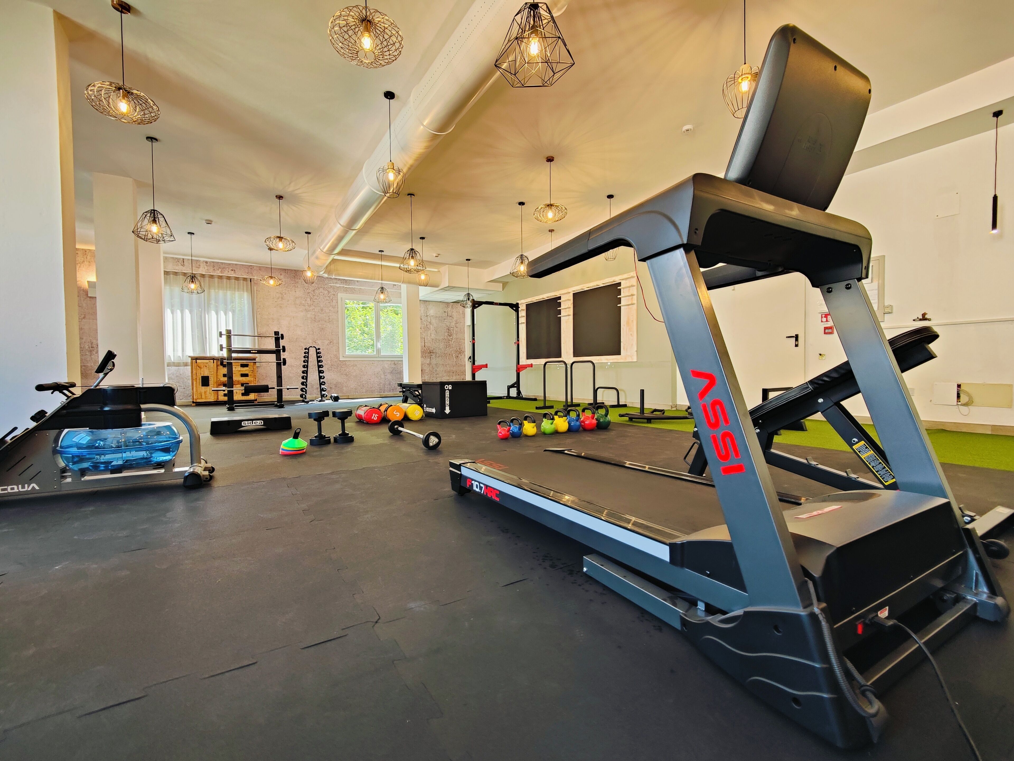 A gym with treadmills, weight plates, and kettlebells.