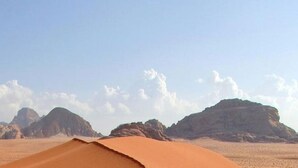 A desert landscape with sand dunes and rocky formations.