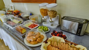 Un bufé de desayuno con diferentes alimentos y un tostador.