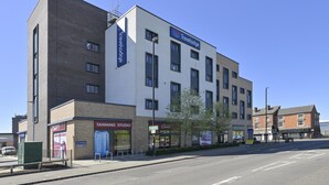 A Travelodge hotel with a modern design, located at the corner of a street. - TRAVELODGE WALSALL (WALSALL)