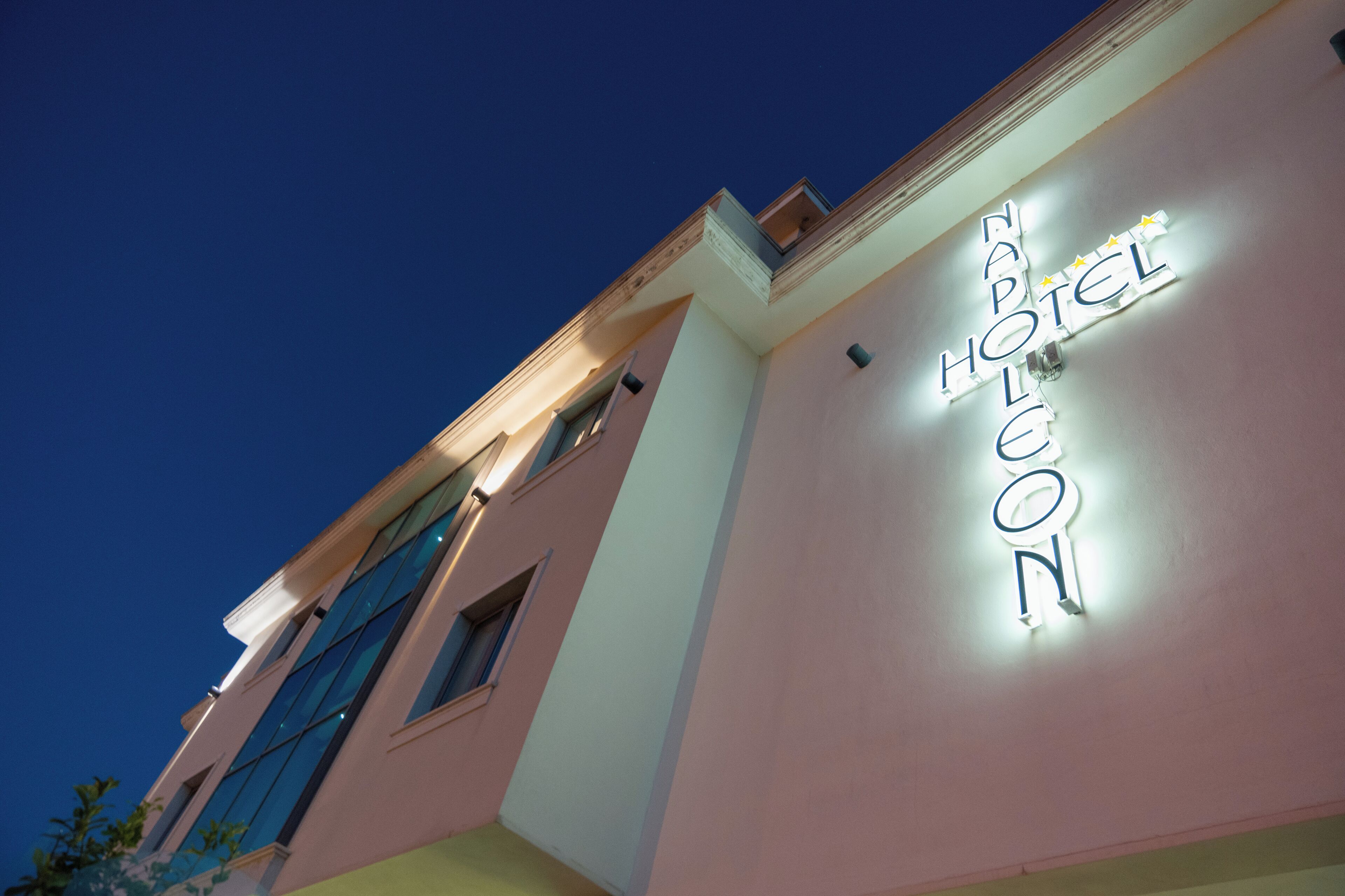 A hotel sign with the name "Hotel Leon" illuminated against a night sky.