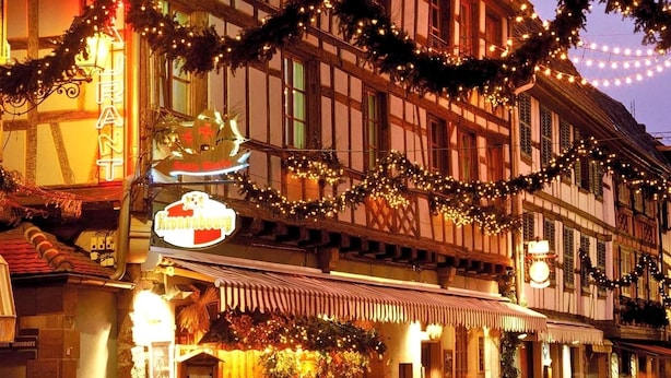 A traditional European building with a sign for a restaurant, decorated with festive garlands and lights. - Hôtel Sainte Odile (Obernai)
