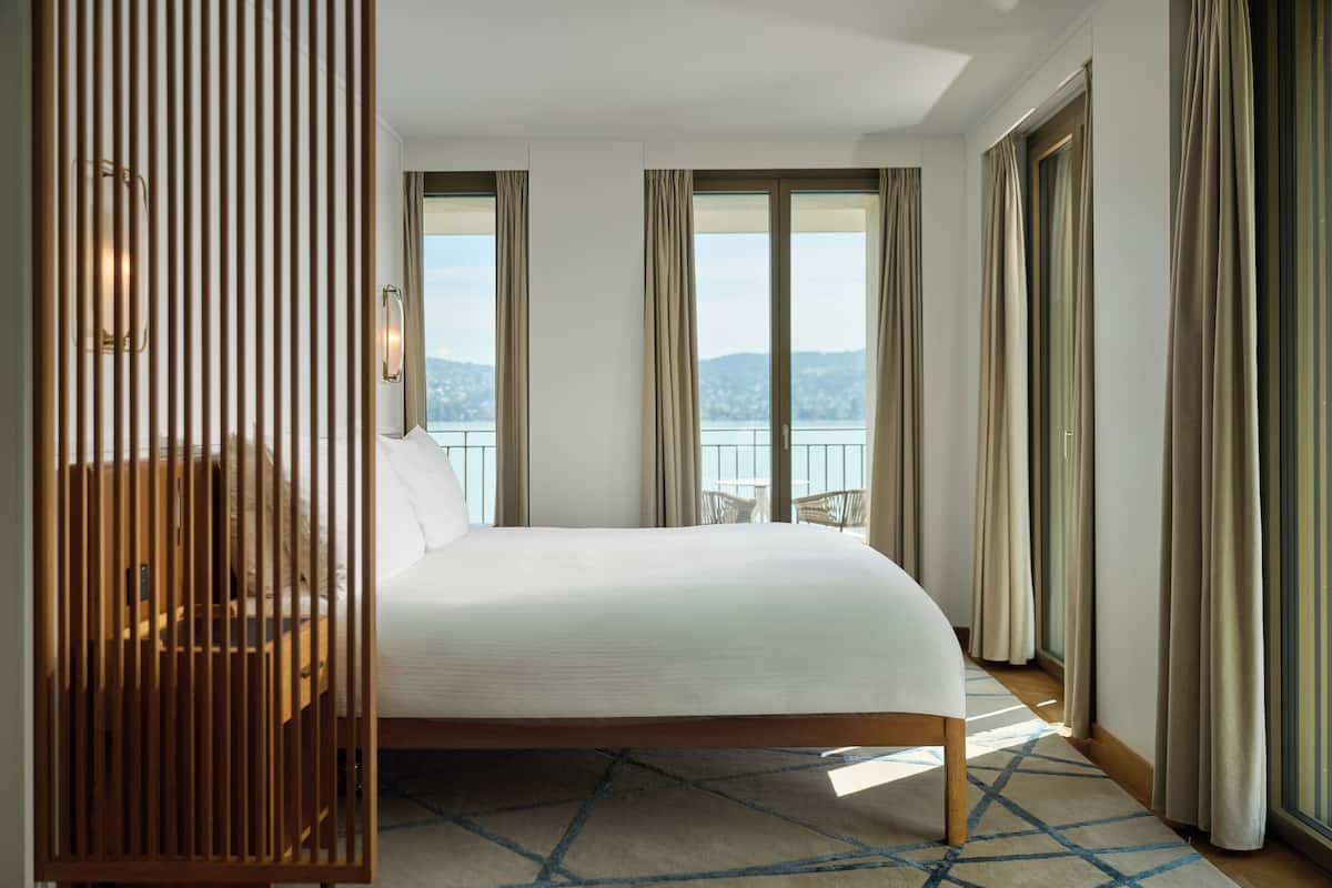 Ett hotellrum med en säng, utsikt över omgivningarna och en balkong.