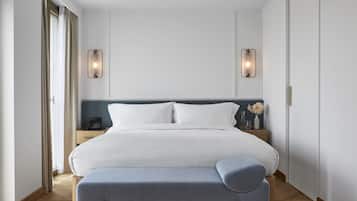 Een moderne hotelkamer met een groot bed, nachtkastjes en een bankje.