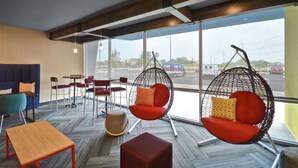 Een modern interieur met hangstoelen, een bank en een tafel.