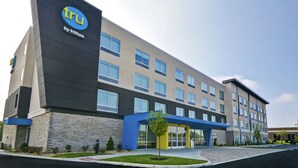 Een modern hotelgebouw met een opvallend ‘tru by Hilton’ bord, meerdere verdiepingen en een verzorgde gevel.
