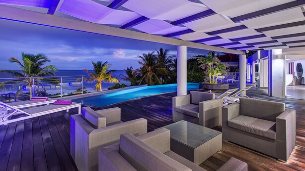 A modern outdoor lounge area with a pool, seating, and a view of the ocean. - At the entrance to Saint François, facing the waves with a panoramic sea view (ST FRANCOIS)