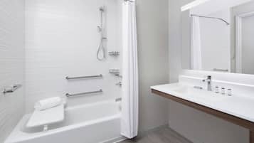 A modern bathroom with a bathtub, shower, and vanity.