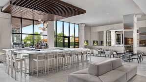 Une cuisine moderne avec un îlot central, des tabourets de bar et un canapé.