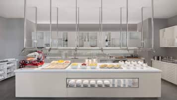 A modern breakfast bar with a variety of food items and a red appliance.