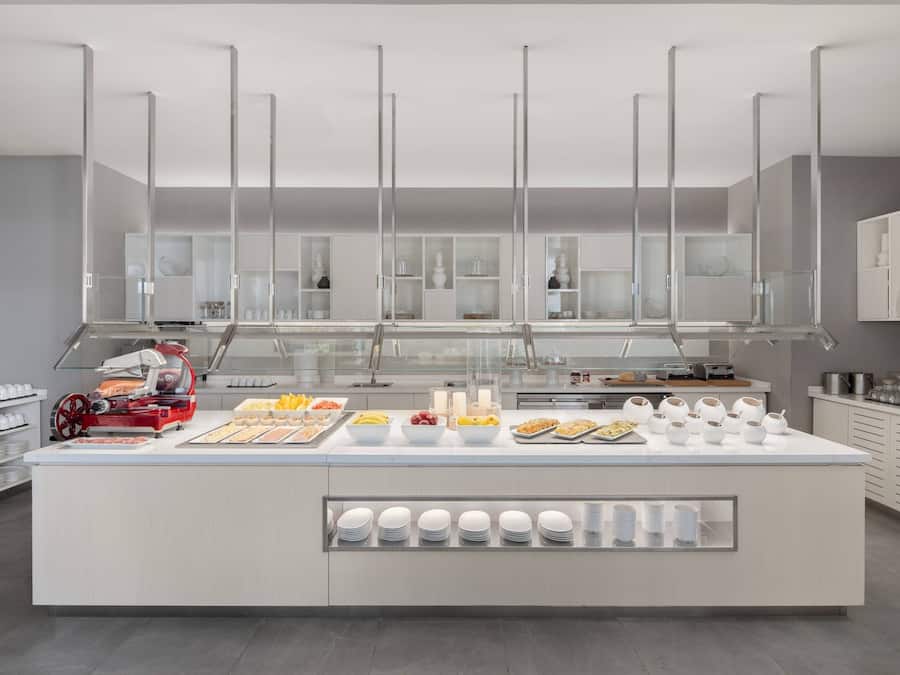 A modern breakfast bar with a variety of food items and a red appliance.