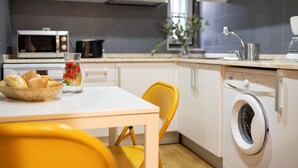 Une cuisine équipée d’un four à micro-ondes, d’un four, d’un évier et d’un lave-linge.