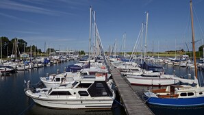 Un port de plaisance où de nombreux bateaux sont amarrés à des quais en bois.