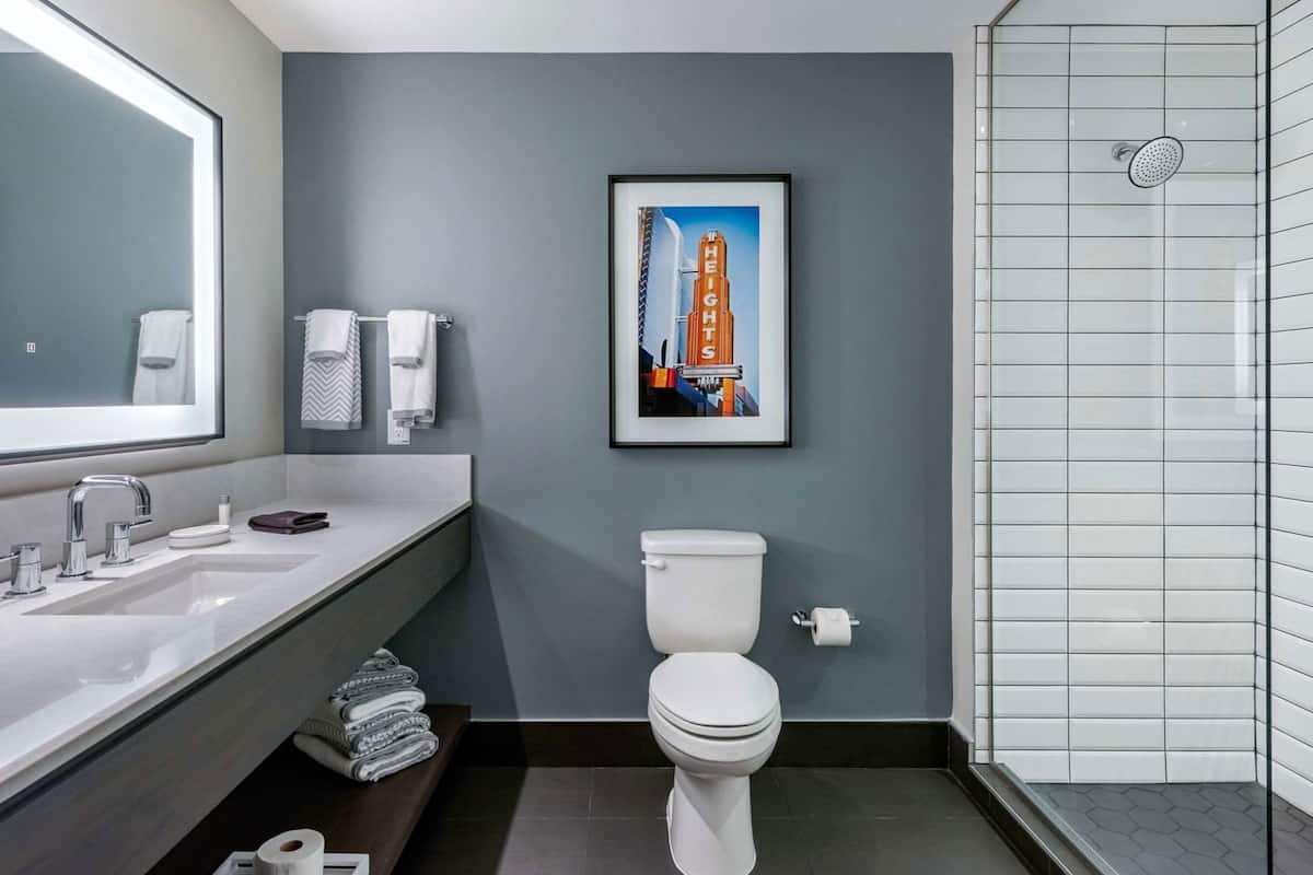 Ein modernes Badezimmer mit großem Spiegel, Waschbecken, Toilette und Dusche.