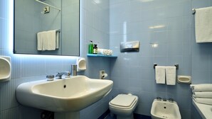 A bathroom with a sink, toilet, bidet, and a mirror. - Sunny apartment view on St. Peter's secure parking (Roma)
