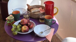 A balcony with a table set for breakfast, including fruits, bread, and beverages. - Sunny apartment view on St. Peter's secure parking (Roma)