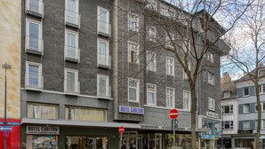 Ein Gebäude mit einem Schild für HOTEL CARLTON und einem sichtbaren Eingang.
