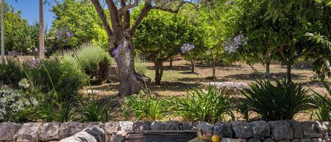 A stone wall with a grill and a stone bench.