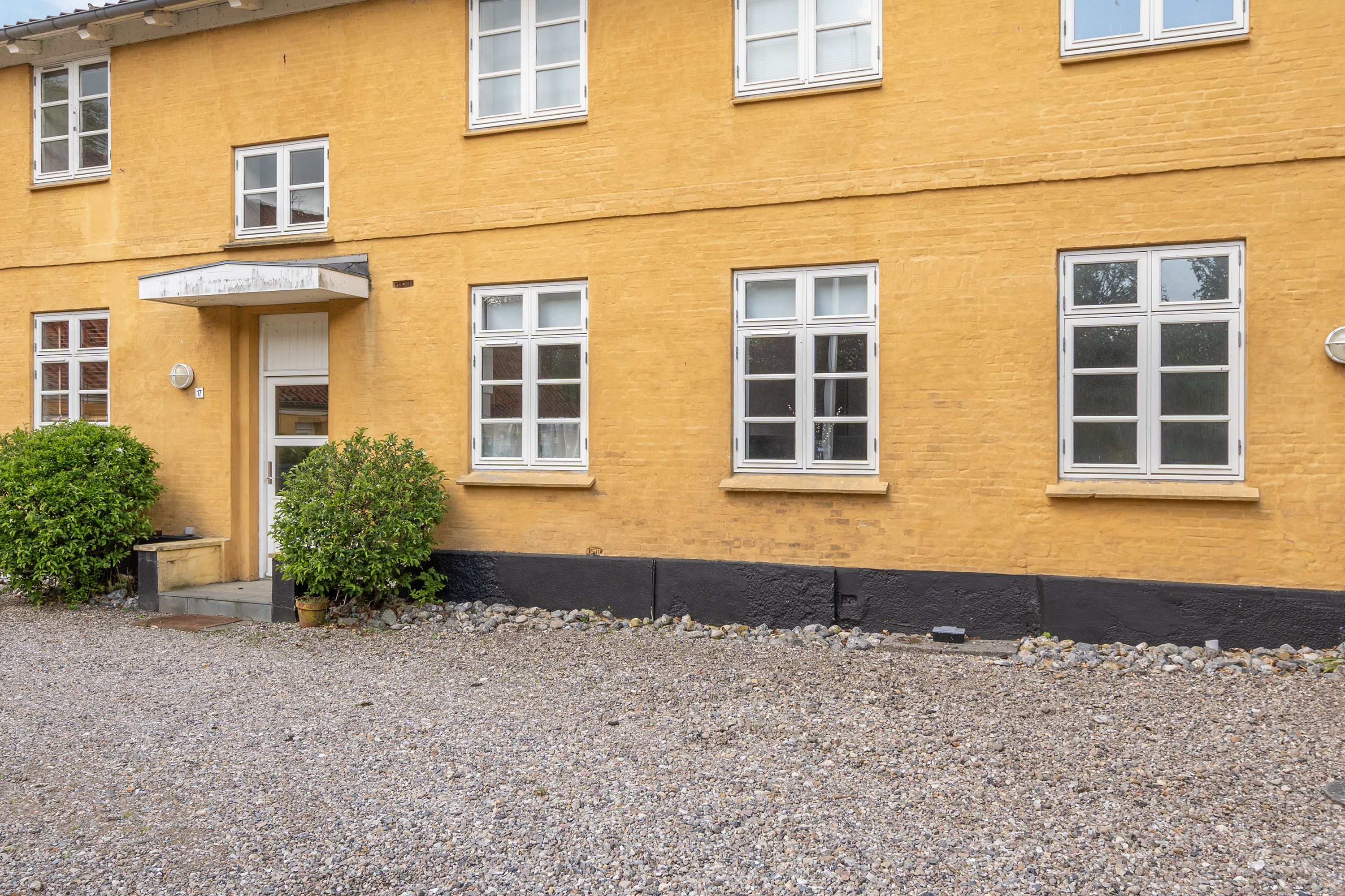 Ein gelbes Gebäude mit vielen Fenstern und einer Tür.