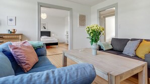 Una sala moderna con un sofá, una mesa de centro y un jarrón decorativo con flores.