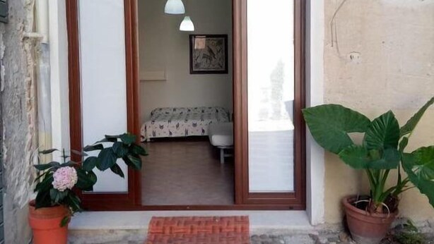 A room with a bed, a desk, and a chair. There is a window and a door. - B&B Garibaldi (Alcamo)