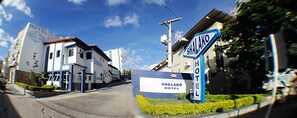 A hotel entrance with a sign reading "Shalako Hotel" and a blue sign indicating the hotel's name.