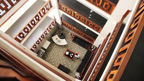 A multi-level hotel lobby with a central seating area, a reception desk, and a staircase. - Shalako Hotel (Vitoria da Conquista)