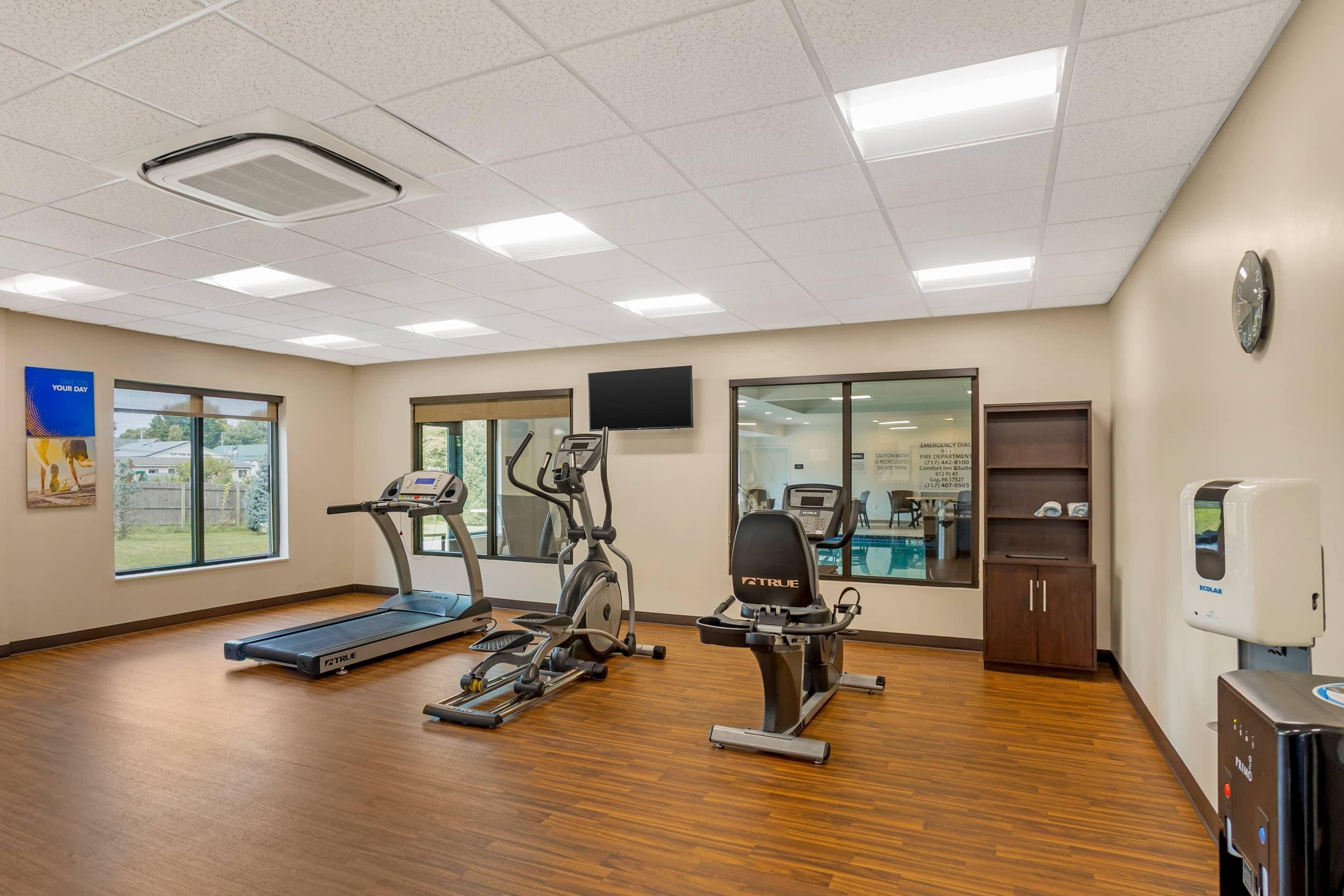 A fitness room with treadmills, an elliptical, and a stationary bike.