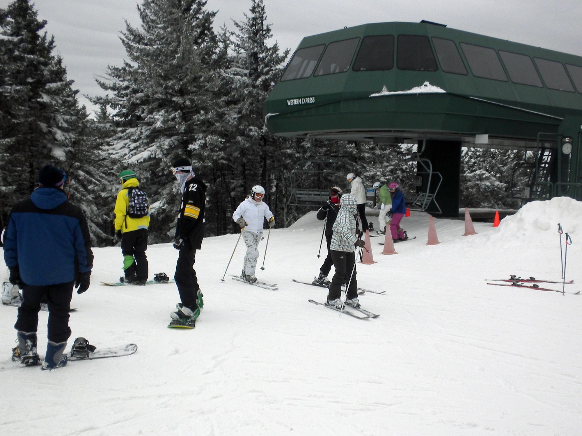 A group of skiers at a ski resort with a covered area labeled "Western Express".