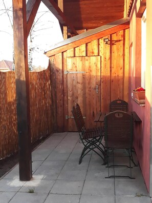 Enjoy dining or socializing in this sheltered patio area with a table and two chairs.