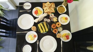 Une table à manger dressée avec différents plats, notamment des toasts, des œufs et une banane.