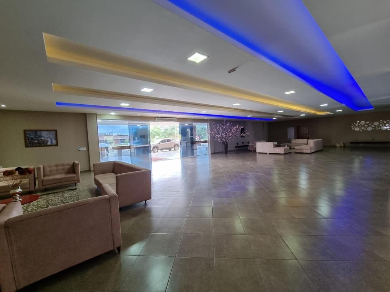 A spacious lobby with a reception desk, seating area, and a view of the outside.