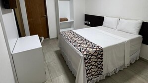 Une chambre à coucher avec un lit, une armoire, une étagère et une porte.