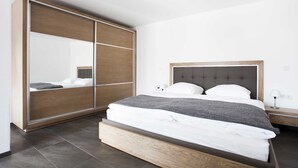 A bedroom with a bed, a wardrobe, and a nightstand. - Modern apartment with sophisticated equipment (Montabaur)