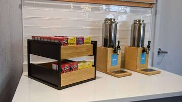 A kitchen counter with cereal boxes, a coffee maker, and a water dispenser.