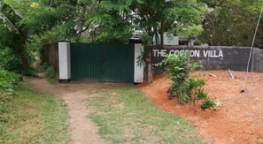 A gated entrance to The Corcoran Villa with a dirt path leading through. - Green Corridor - Ahangama (Ahangama)