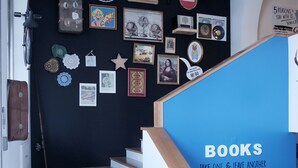 A staircase with a blue handrail and a sign that reads "BOOKS TAKE ONE & LEAVE ANOTHER". - Hi Go Hostel & Suites (Vila Nova de Famalicao)
