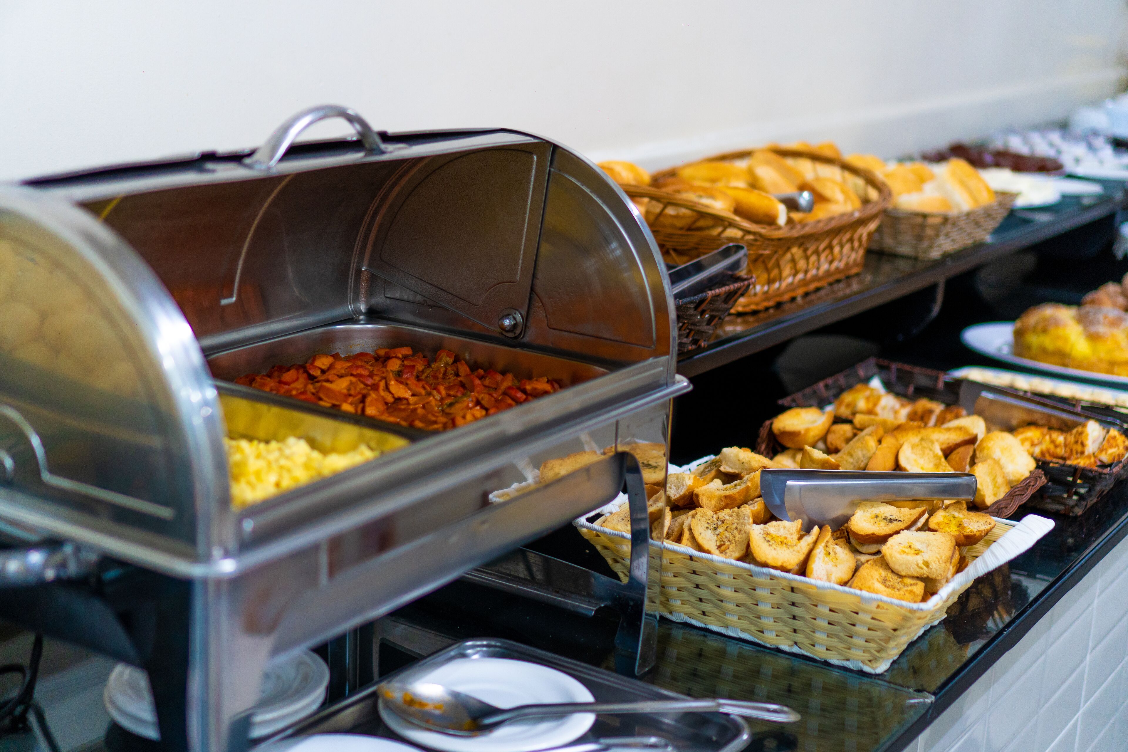 Un bufé con diferentes opciones de comida, incluyendo cazuelas, panadería y pastelería.