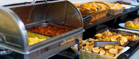 Un bufé con diferentes opciones de comida, incluyendo cazuelas, panadería y pastelería.