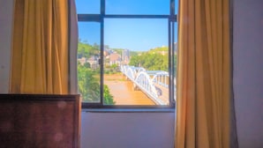 Una habitación con ventana que da a un puente y un río.