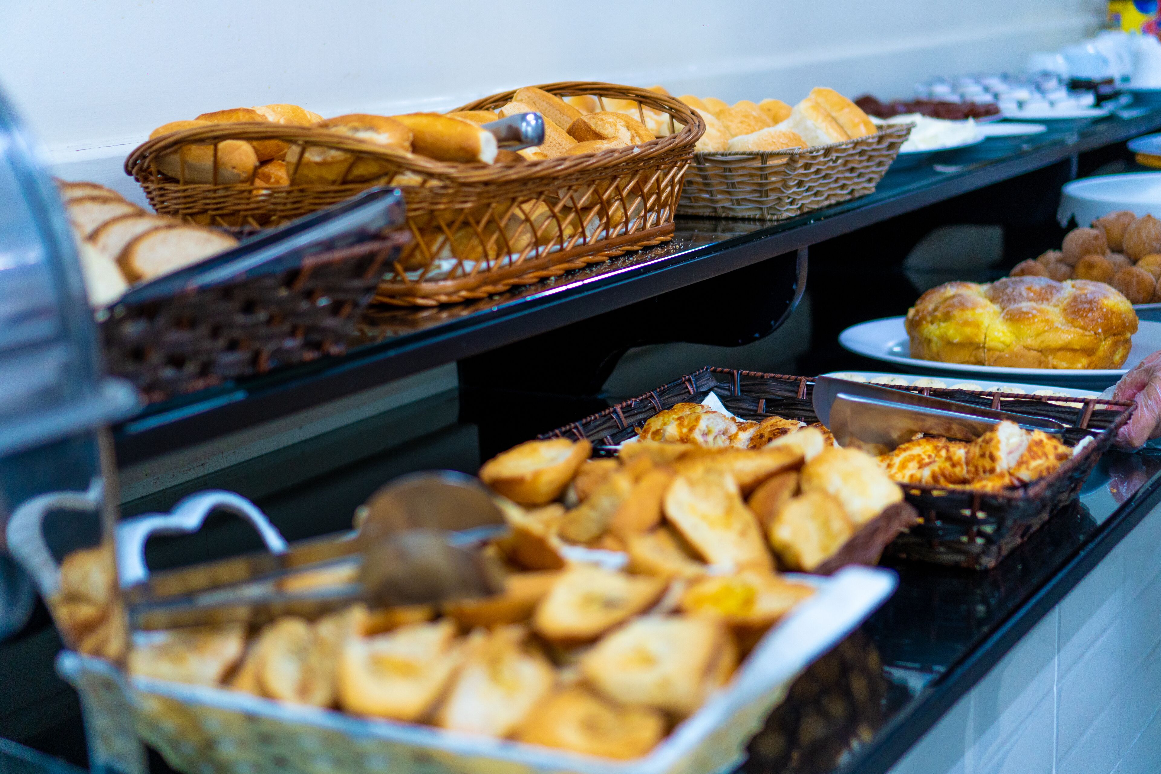 Een buffet met diverse gebakken producten, zoals brood, gebak en broodjes.