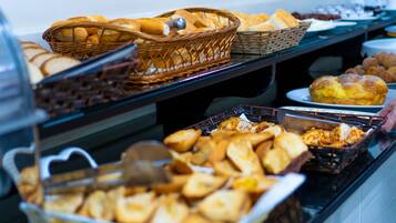Een buffet met diverse gebakken producten, zoals brood, gebak en broodjes.